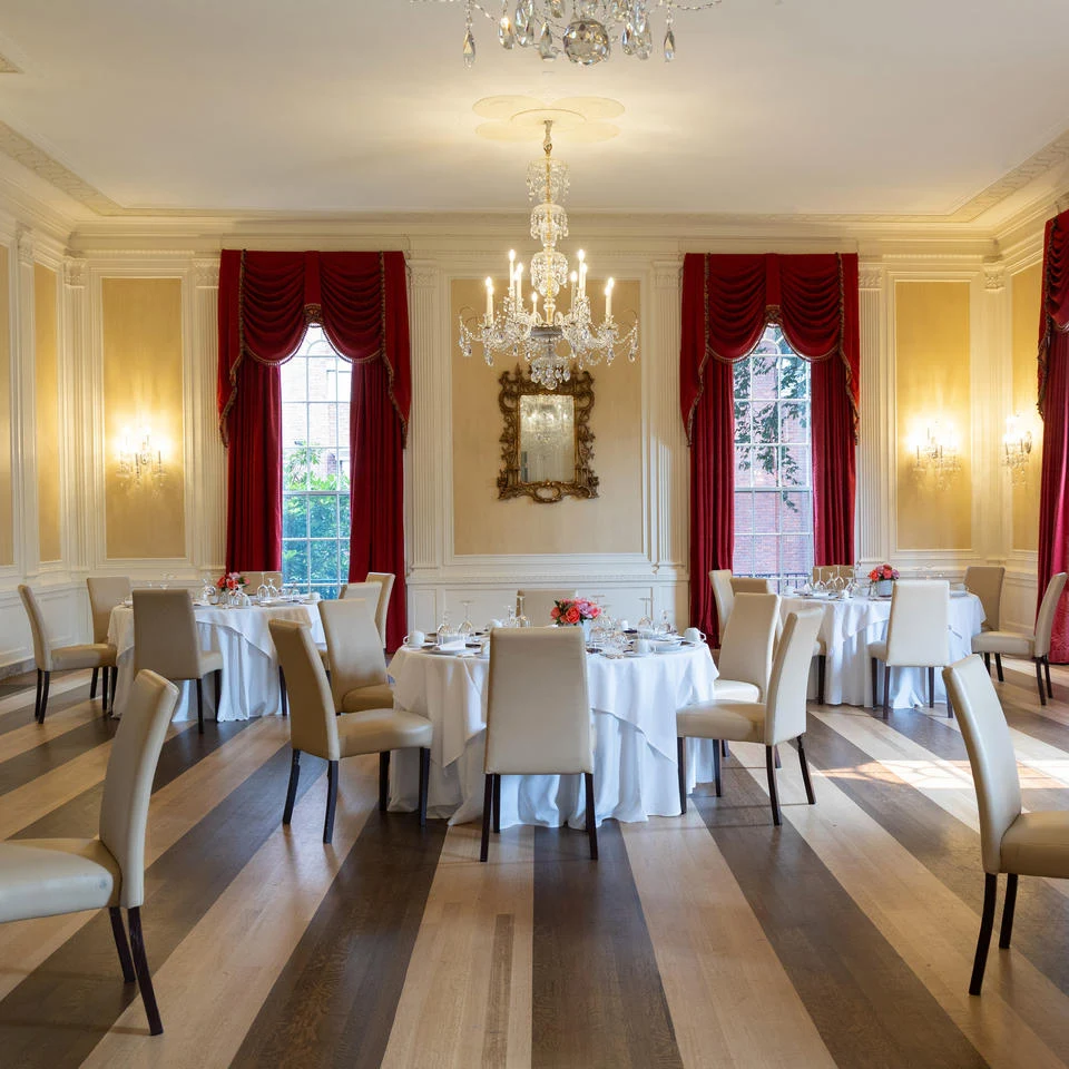 Sunlit Loeb House ballroom, showing its chandelier, parquet floor and period interior